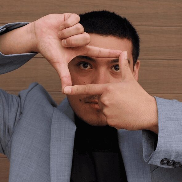 Man framing eye with hands like camera