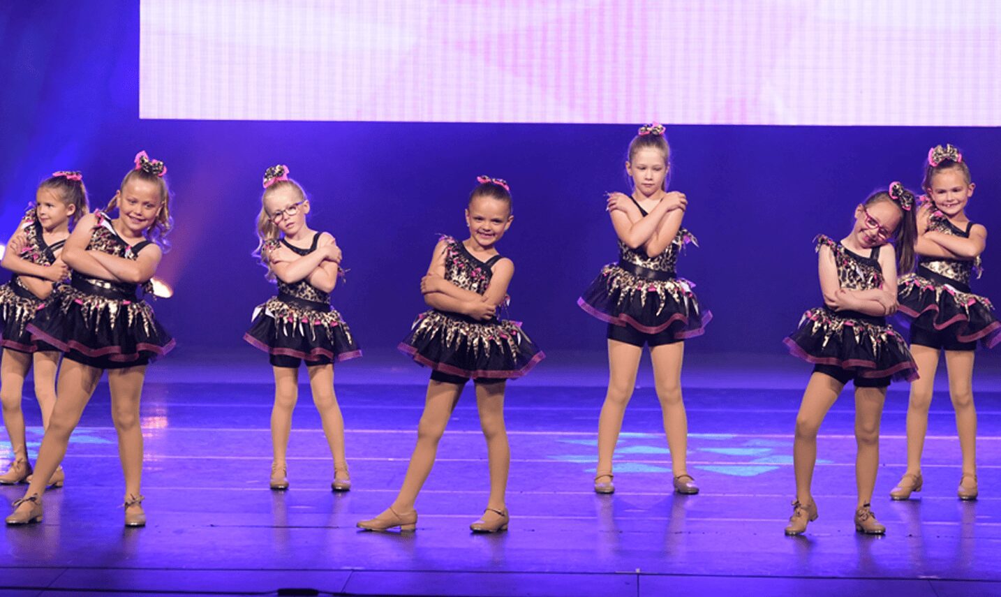 Young dancers arms crossed in black tutus
