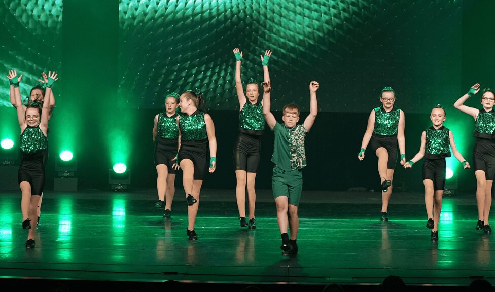 Young dancers performing in green sequined outfits